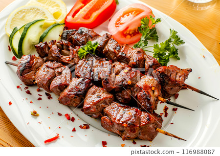 kebab served on a plate with vegetables a popular barbecue dish 116988087