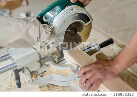 Cutting wood with an electric saw Cutting wood with an electric saw 116988328