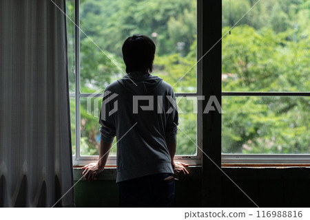 Back view of a person looking out the window 116988816