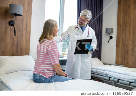 Male doctor looking friendly while talking to a female patient 116989527