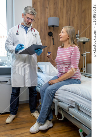 Male doctor talking to a female patient in the hospital 116989538