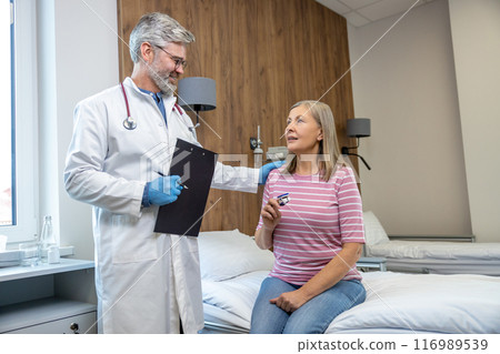Male doctor talking to a female patient in the hospital Male doctor talking to a female patient in the hospital 116989539