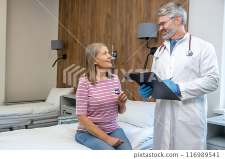 Male doctor talking to a female patient in the hospital Male doctor talking to a female patient in the hospital 116989541