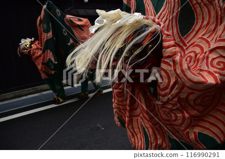 Takayama City, Gifu Prefecture, Japan: Traditional performing arts at the Takayama Spring Festival. Lion dancers parade through the streets in festival costumes, shaking the lion's face. 116990291