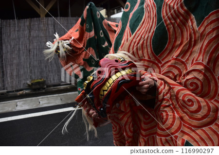 Takayama City, Gifu Prefecture, Japan: Traditional performing arts at the Takayama Spring Festival. Lion dancers parade through the streets in festival costumes, shaking the lion's face. Takayama City, Gifu Prefecture, Japan: Traditional performing arts at the Takayama Spring Festival. Lion dancers parade through the streets in festival costumes, shaking the lion's face. 116990297