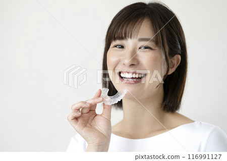 拿著喉舌的微笑的年輕女子 116991127