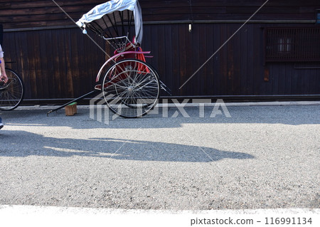 Spring in Japan, Takayama City, Gifu Prefecture, A rickshaw parked in front of an old house, a retro car body and a Japanese house, the shadows of people passing by 116991134