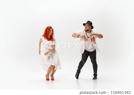 Classic dancers practice salsa passionately, perfecting each step and rhythm with dedication and energy against white studio background. 116991362