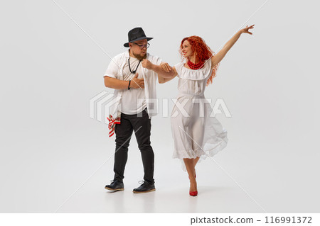 Love for dance. Focused on perfecting salsa technique, dancers rehearses with enthusiasm and precision against white studio background. Love for dance. Focused on perfecting salsa technique, dancers rehearses with enthusiasm and precision against white studio background. 116991372