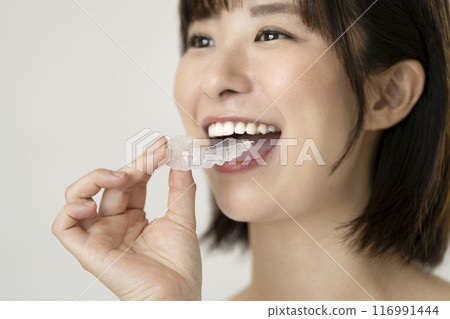 The hand of a young woman holding a mouthpiece 116991444