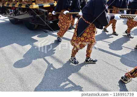 Takayama Festival in Spring, Takayama City, Gifu Prefecture, Japan. Men carrying gorgeous floats, wearing flashy costumes and straw sandals. Takayama Festival in Spring, Takayama City, Gifu Prefecture, Japan. Men carrying gorgeous floats, wearing flashy costumes and straw sandals. 116991739