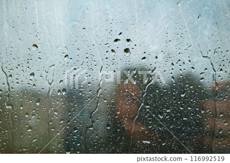 Water drops on glass window with autmn forest background Water drops on glass window with autmn forest background 116992519