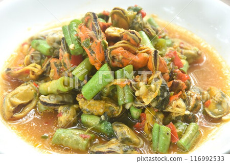 spicy stir fried mussel with slice yard long bean and basil leaf on plate  116992533