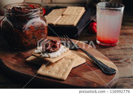 Crackers with cream cheese and sun-dried tomatoes 116992776