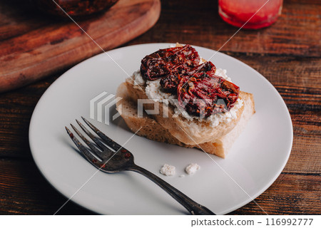 Toast with homemade sun-dried tomatoes and cream cheese on a plate 116992777