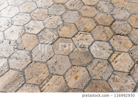 Old stone flooring made of beige hexagon tiles, background photo 116992930
