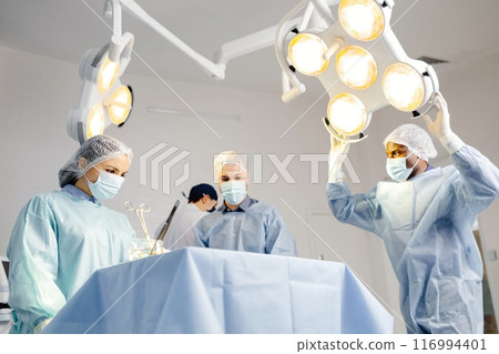 Group of doctors performing surgery in hospital 116994401