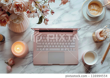 Laptop is on a table with a vase of flowers and a cup of coffee 116994554