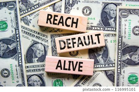 Reach default alive symbol. Concept words Reach default alive on wooden blocks on a beautiful background from dollar bills. Business, finacial and reach default alive concept. 116995101