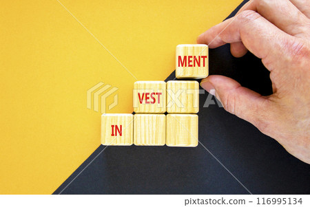 Investment symbol. Concept word Investment on beautiful wooden blocks. Businessman hand. Beautiful yellow and black background. Business investment concept. Copy space. Investment symbol. Concept word Investment on beautiful wooden blocks. Businessman hand. Beautiful yellow and black background. Business investment concept. Copy space. 116995134