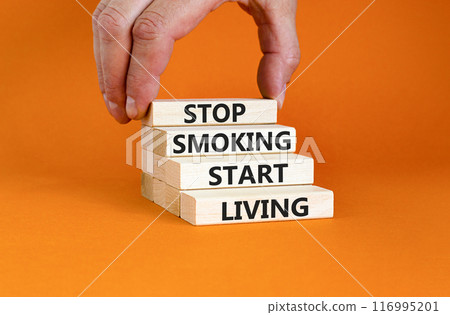 Stop smoking start living symbol. Concept words Stop smoking start living on cubes. Beautiful orange background. Doctor hand. Medical healthy lifestyle stop smoking start living concept. Copy space. Stop smoking start living symbol. Concept words Stop smoking start living on cubes. Beautiful orange background. Doctor hand. Medical healthy lifestyle stop smoking start living concept. Copy space. 116995201