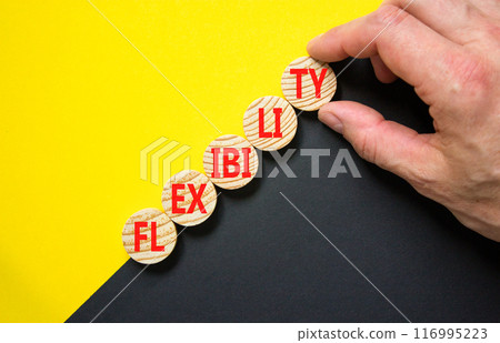 Flexibility symbol. Concept word Flexibility on beautiful wooden circles. Beautiful yellow and black background. Businessman hand. Business flexibility concept. Copy space. 116995223