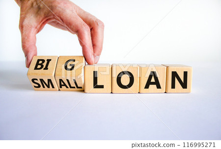 Big or small loan symbol. Businessman turns a wooden cube and changes words 'small loan' to 'big loan'. Beautiful white table, white background, copy space. Business and big or small loan concept. 116995271