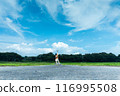 A man holds a drone up into the summer sky 116995508