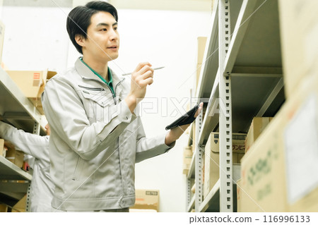 A young man manages inventory using pen input 116996133