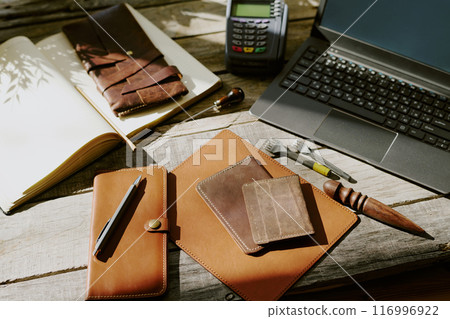 High angle shot of old wooden table with leather goods, leather punches and gadgets High angle shot of old wooden table with leather goods, leather punches and gadgets 116996922