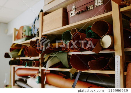Medium close up of upper shelves full of natural leather rolls and antique suitcases 116996989