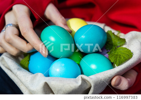 Serene Woman Holding Basket of Colorful Easter Eggs Serene Woman Holding Basket of Colorful Easter Eggs 116997383
