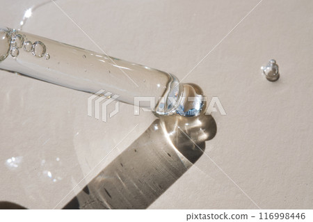 Pipette with serum on a beige background. 116998446