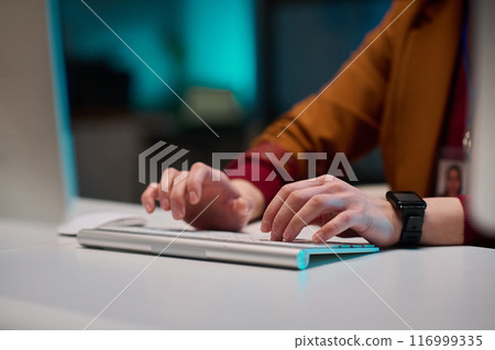 Closeup of female hands typing on wireless computer keyboard while working at desk in office copy space 116999335