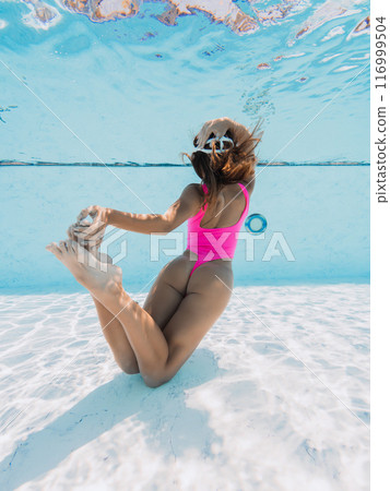Beauty woman in  swimwear posing underwater in pool. Sexy girl with perfect body dive in swimming pool 116999504