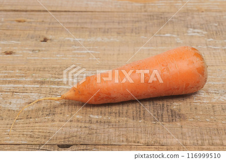 A Fresh Organic Carrot Placed Beautifully on a Rustic Wooden Surface for Presentation A Fresh Organic Carrot Placed Beautifully on a Rustic Wooden Surface for Presentation 116999510