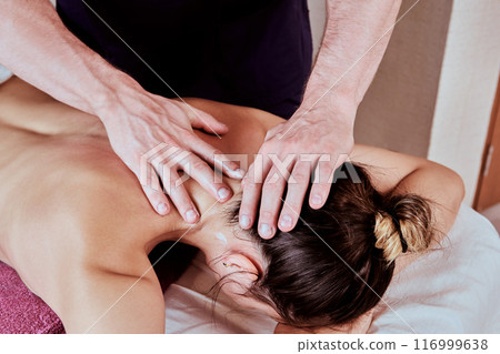 Massaging neck muscles during back massage for young woman 26 years old. Massaging neck muscles during back massage for young woman 26 years old. 116999638