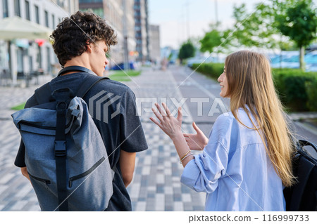 View from back, walking friends, guy and girl university students with backpacks 116999733