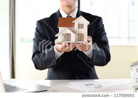 穿著西裝的男性辦公室職員拿著房屋模型 穿著西裝的男性辦公室職員拿著房屋模型 117000001