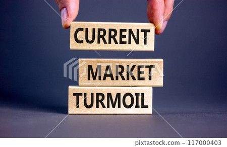 Current market turmoil symbol. Concept words Current market turmoil on wooden blocks on a beautiful grey table grey background. Businessman hand. Business, finacial current market turmoil concept. Current market turmoil symbol. Concept words Current market turmoil on wooden blocks on a beautiful grey table grey background. Businessman hand. Business, finacial current market turmoil concept. 117000403