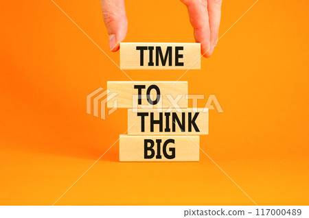 Time to think big symbol. Concept words Time to think big on beautiful wooden block. Beautiful orange table orange background. Businessman hand. Business and time to think big concept. Copy space. Time to think big symbol. Concept words Time to think big on beautiful wooden block. Beautiful orange table orange background. Businessman hand. Business and time to think big concept. Copy space. 117000489