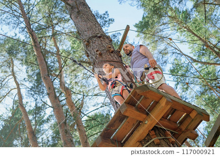 The girl is preparing for the descent of the suspended trolley The girl is preparing for the descent of the suspended trolley 117000921