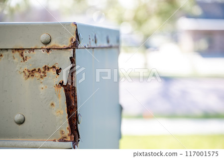 Rusted and peeling paint on an electrical transformer exposed to the elements.  117001575