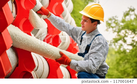 Worker Handling Large White Rolls of Insulation on Construction Site. Generative AI Worker Handling Large White Rolls of Insulation on Construction Site. Generative AI 117001647