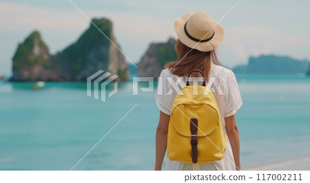 Woman Enjoys Serene View of Islands From Beach at Sunset 117002211