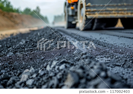 Road construction workers' teamwork, tarmac laying works at a road construction site 117002403