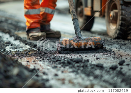 Road construction workers' teamwork, tarmac laying works at a road construction site Road construction workers' teamwork, tarmac laying works at a road construction site 117002419