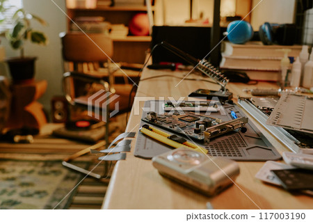 Medium close up of laptop parts of different sizes on wooden table in cozy room 117003190