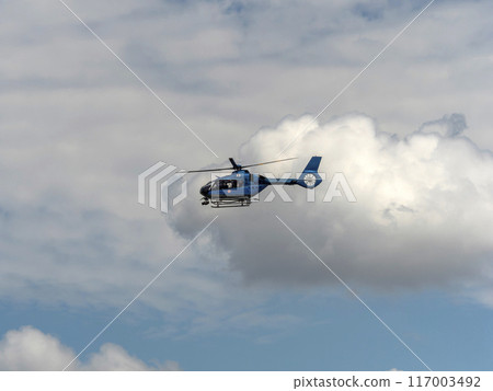 A helicopter of the Osaka Prefectural Police Aviation Unit flying in the midsummer sky 117003492