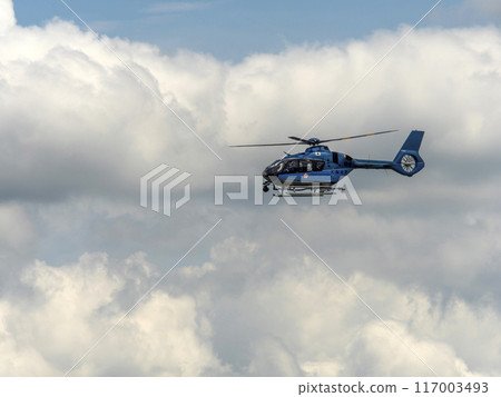 A helicopter of the Osaka Prefectural Police Aviation Unit flying in the midsummer sky 117003493